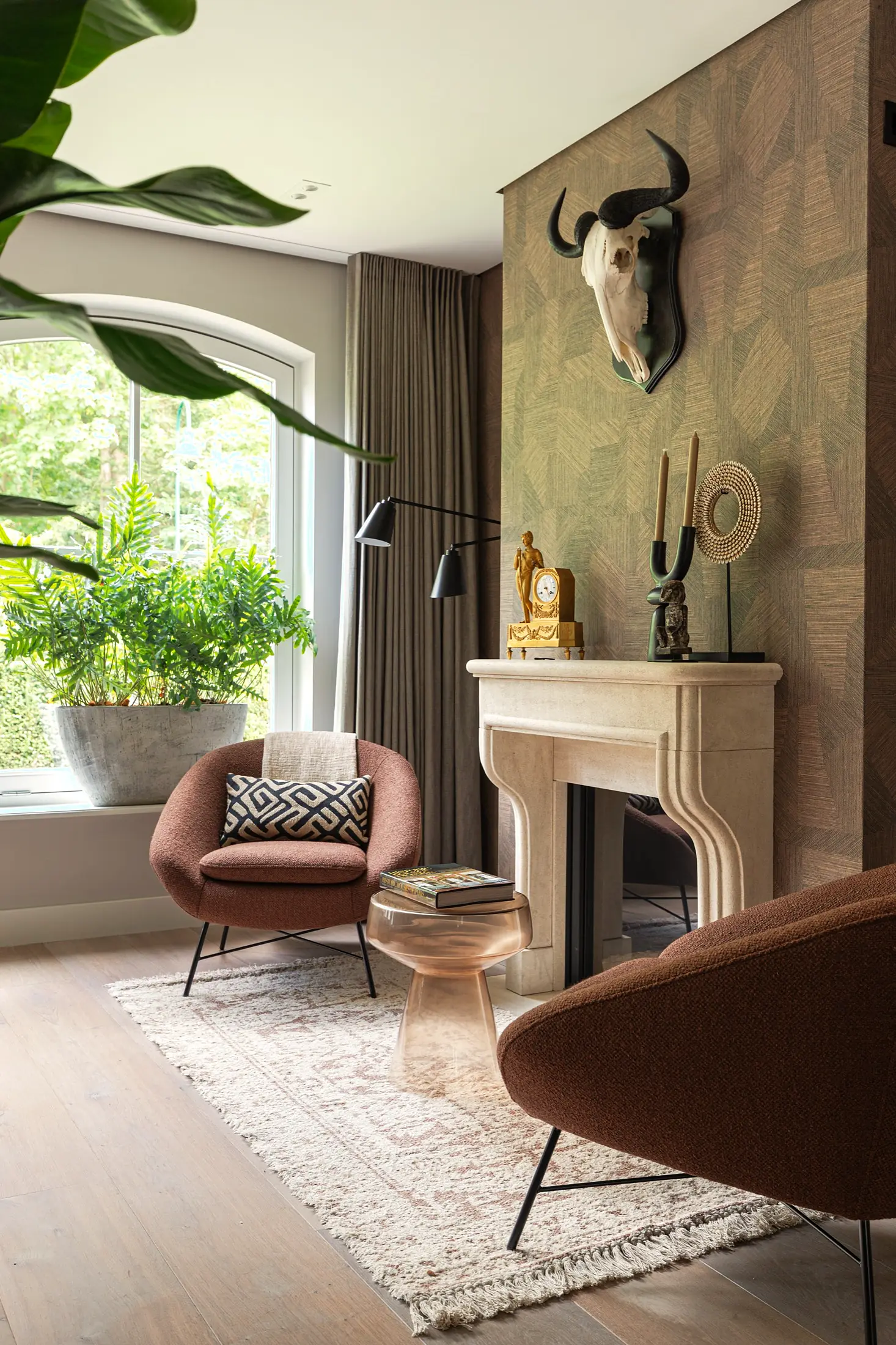 Cognac fauteuil bij een marmeren schouw in een VINC-interieur