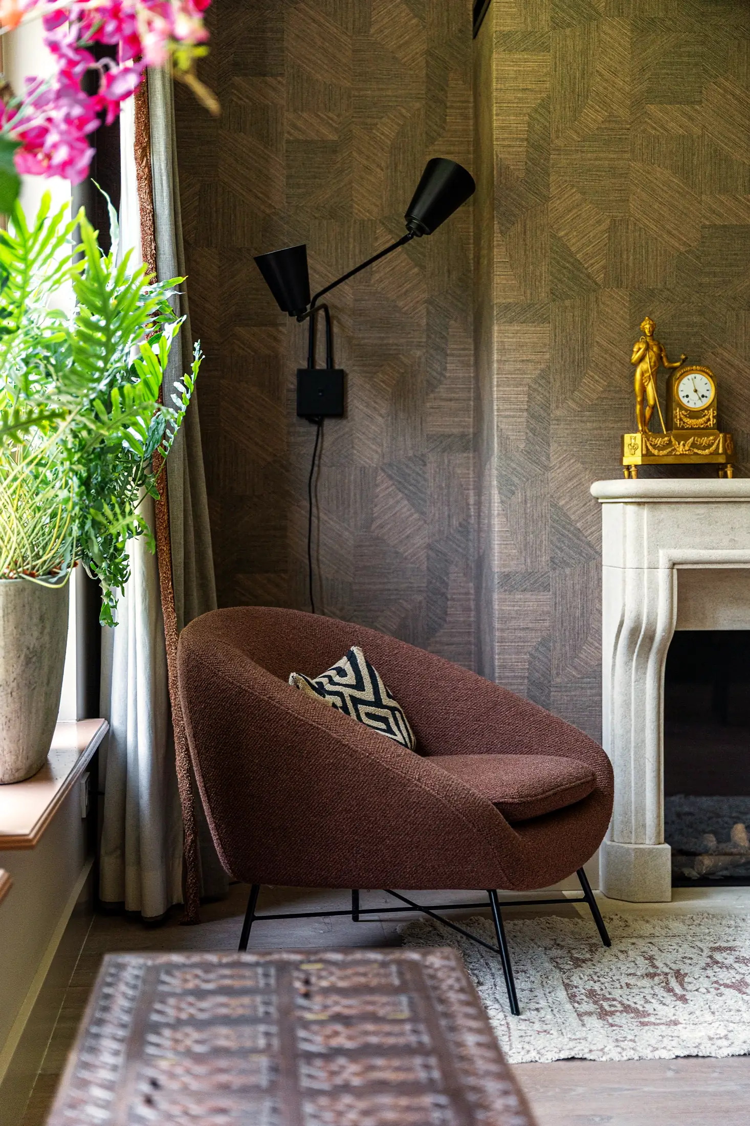 Terracotta fauteuil bij schouw met gouden pendule - VINC sfeerbeeld